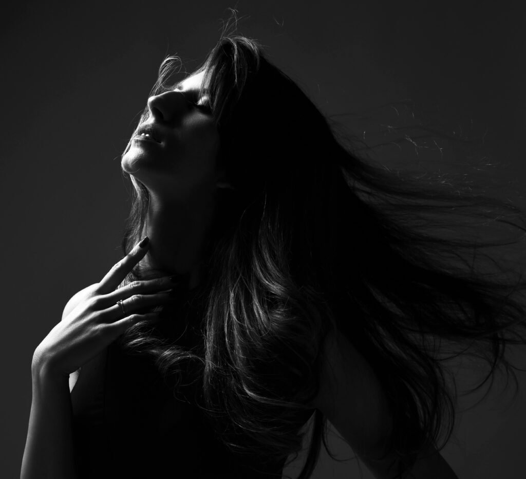 Black and white fashion art studio portrait of beautiful elegant woman with windy hair